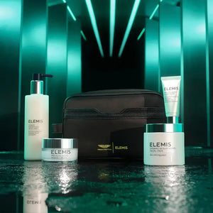 The ELEMIS – ASTON MARTIN DELUXE SKINCARE COLLECTION by ELEMIS – STEINER features a green gift box, black toiletry bag, and four luxury skincare products—including the Dynamic Resurfacing Facial Wash—against a white background.