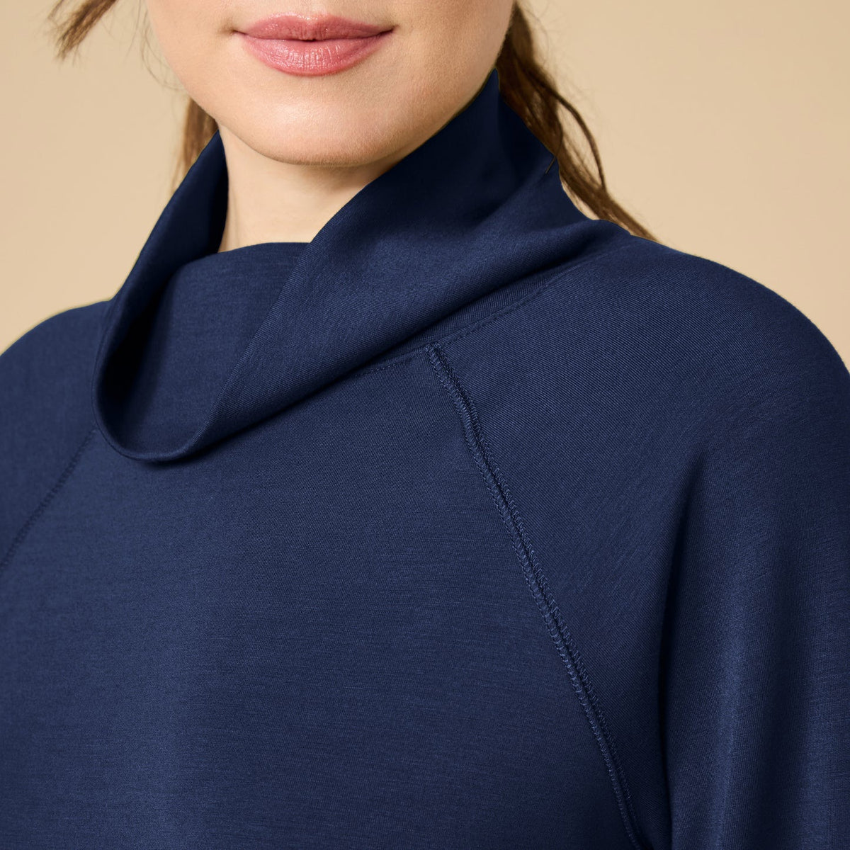 A woman seen from behind wearing the fuchsia SOFTIES - DREAMTECH COWL NECK WITH PLEATED PANT set featuring a long-sleeved cowl neck top and matching pleated pants.
