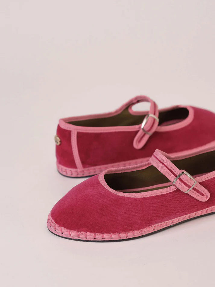 A single SVETI STEFAN - MARY JANE SHOE with a buckle strap, handmade in Spain, is displayed on a plain light background. The shoe features a dark pink body with lighter pink trim and a light pink sole, all crafted from cotton fabric.