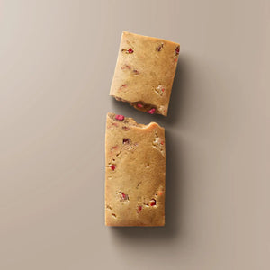 A maroon STARS+HONEY - RASPBERRY DONUT protein bar is shown. This raspberry donut-flavored bar from STARS+HONEY highlights 10g collagen, 14g protein, and only 2g sugar per bar on the front of the package—making it a perfect healthy snack.