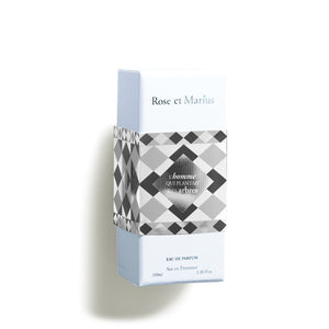 A light blue rectangular box labeled "ROSE ET MARIUS - THE MAN WHO PLANTED TREES EAU DE PARFUM 100ML" features geometric black, white, and gray patterns and hints at a woody fragrance. "Eau de Parfum" and "100 ml" appear at the bottom.