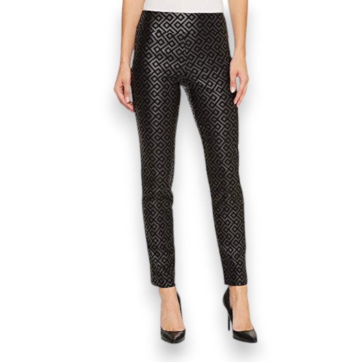 The image showcases a person wearing the KRAZY LARRY, INC PULL ON ANKLE PANT in black, adorned with a geometric pattern and styled with black high heels. The focus is on the lower half of the outfit, accentuating a sleek silhouette.