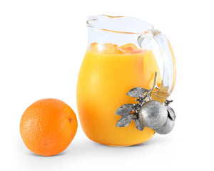 The VAGABOND HOUSE - ORANGE BLOOMS GLASS PITCHER features a clear glass design with a distinctive handle adorned in luxury-grade pewter, showcasing metallic textured oranges and leaves, creating an elegant contrast to the simple transparency of the pitcher.