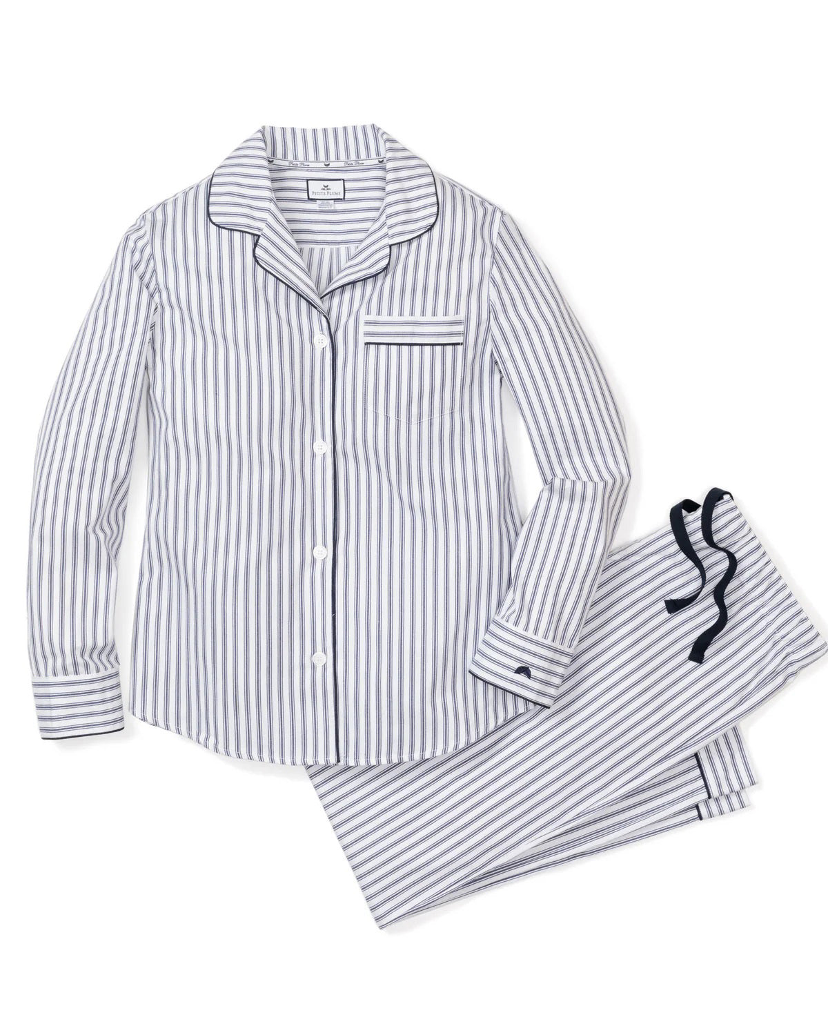 A neatly folded navy and white striped pajama set with a collar and buttons, featuring a small patch pocket on the chest. This classic pajama set from the Fearrington Lifestyle Collection is crafted from cotton twill in a traditional French ticking design, displaying the "Petite Plume" label on the inside collar and sporting a branded tag near the top.