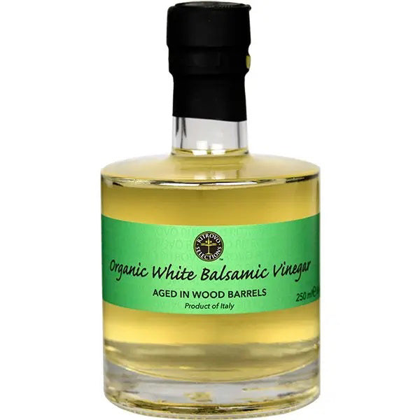 A bottle of USDA Certified Organic White Balsamic Vinegar from the brand RITROVO, featuring a green label that reads, "ORGANIC WHITE BALSAMIC VINEGAR, Aged in Wood Barrels with Trebbiano white grape must, Product of Italy, 250ml." The clear glass bottle has a black cap and contains light golden vinegar.