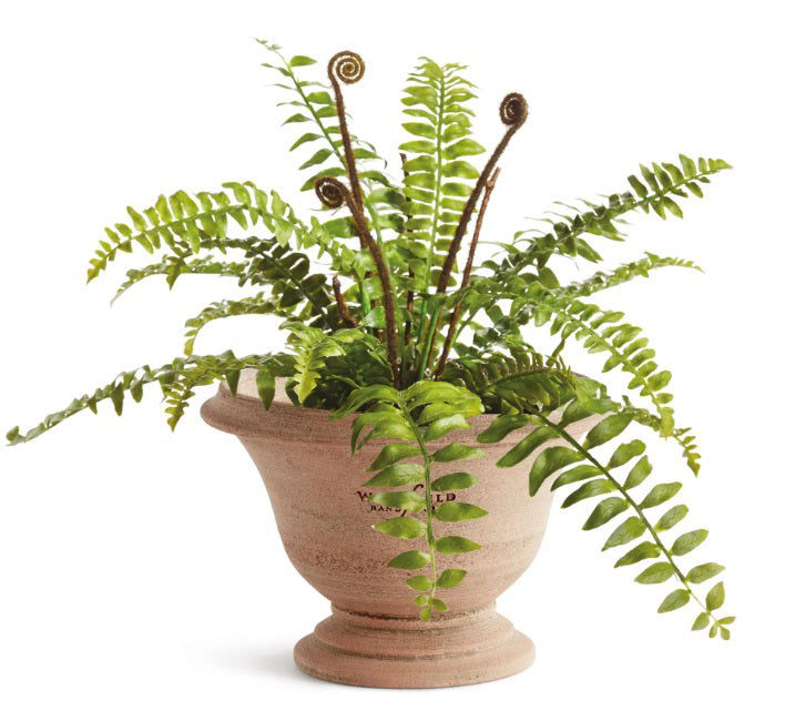 The NAPA HOME AND GARDEN - WAKEFIELD HANDMADE ASTON POT, crafted from aged terracotta with a wide rim and round base, sits on a stone surface beside another decorative planter in the background.