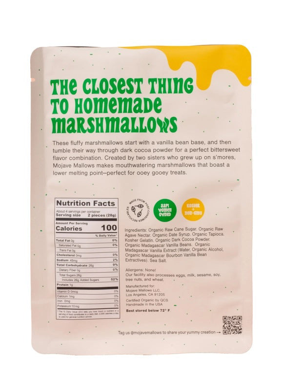 A white upright bag of MOJAVE MALLOWS - COCOA DIPPED MARSHMALLOWS by MOJAVE MALLOWS features green and yellow text, a bright yellow graphic, and a USDA organic label on the front, highlighting this delicious handmade treat. Each marshmallow is infused with organic vanilla and coated in rich dark cocoa powder for an irresistible snack.