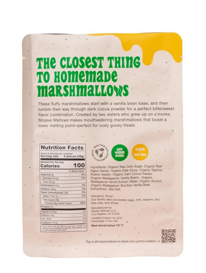 A white upright bag of MOJAVE MALLOWS - COCOA DIPPED MARSHMALLOWS by MOJAVE MALLOWS features green and yellow text, a bright yellow graphic, and a USDA organic label on the front, highlighting this delicious handmade treat. Each marshmallow is infused with organic vanilla and coated in rich dark cocoa powder for an irresistible snack.