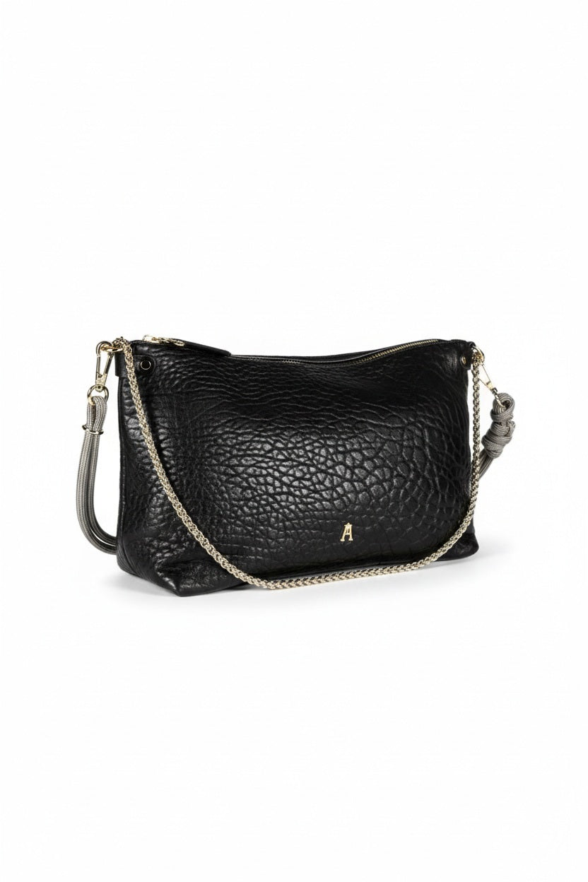 The CRAIE STUDIO - MALLOW BUBBLE NOIR HANDBAG features black bubble leather, a luxurious gold zipper, and an elegant gold chain strap. Displayed against a white background, this chic piece from CRAIE STUDIO adds sophisticated style to any outfit.