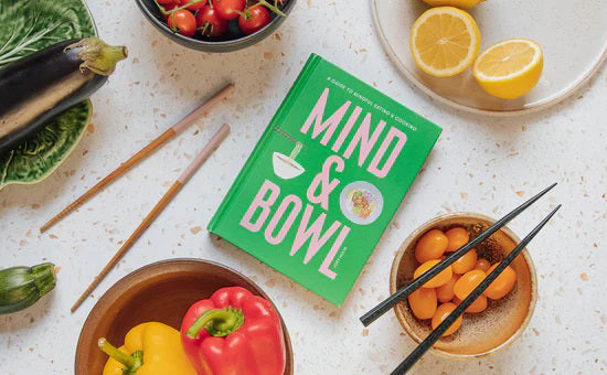 Book cover for MIND & BOWL: A GUIDE TO MINDFUL EATING & COOKING BY JOEY HULIN from PETITECOLLAGE featuring a bowl of noodles and a bowl of food on a green background. The pink text reads: "A Guide to Mindful Eating & Cooking. Mind & Bowl. Joey Hulin." Ideal for those interested in mindful eating, this book from PETITECOLLAGE encourages readers to explore the relationship between mindfulness and food with inspiring, simple bowl recipes.