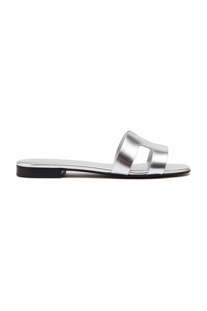 The MICHELE LOPRIORE - H SLIDE is a brown leather sandal with two wide straps, including one with a rectangular cutout, featuring a flat wooden sole. Made in Italy by MICHELE LOPRIORE, it's shown on a white background.