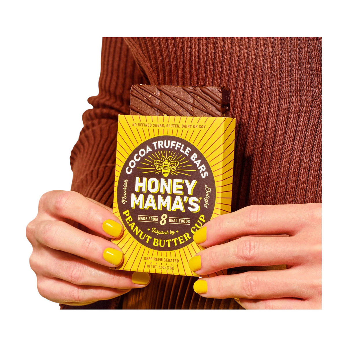 Yellow box of HONEY MAMA&#39;S- PEANUT BUTTER CUP cocoa truffle bars, made with chocolate and raw honey. Features “8 real foods,” “no refined sugar, gluten, dairy or soy,” and an illustrated bee above the product name.