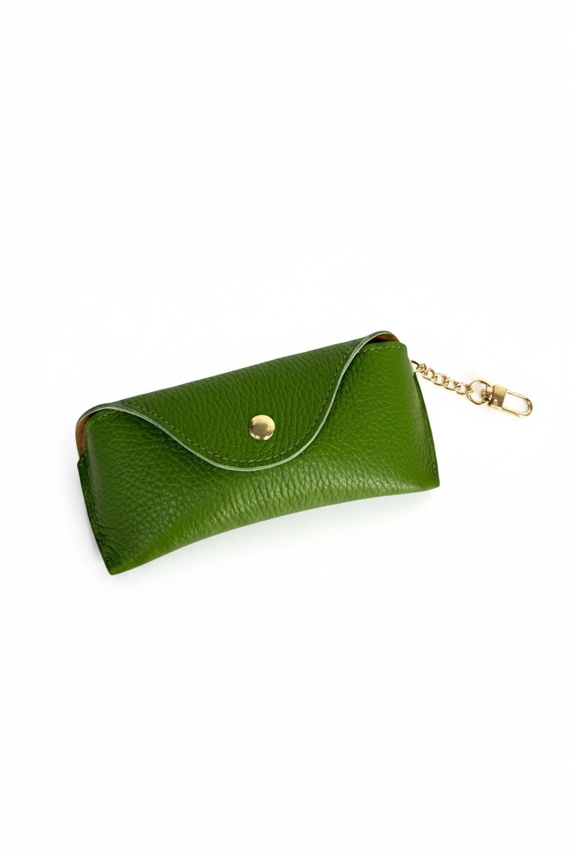 LEATHER EYEGLASS CASE IN GREEN made of green leather with a gold snap closure and an attached gold chain clip.
