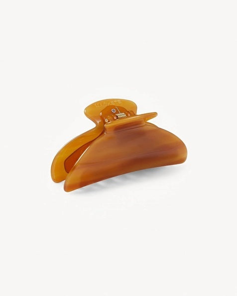 The MACHETE - MIDI HEIRLOOM CLAW by MACHETE is a pink and orange marbled hair claw clip, expertly crafted from premium Italian acetate. It features a curved design, wide grip, and interlocking teeth for a secure hold—ideal for medium volume hair. Shown against a plain white background.