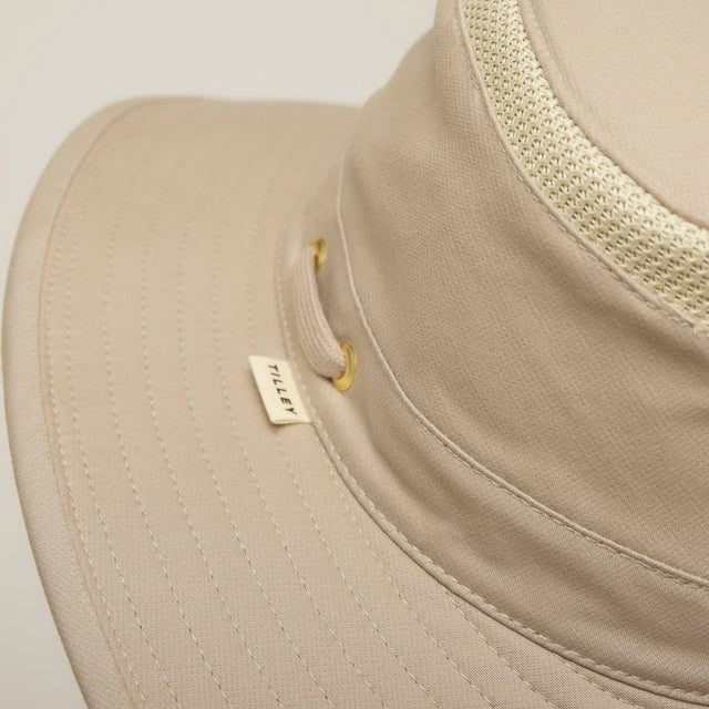 A man with a gray beard wears the TILLEY - AIRFLO HIKERS HAT T4MO-1 IN KHAKI OLIVE, featuring UPF 50+ sun protection, and a matching collared shirt, shown in profile against a plain light background.