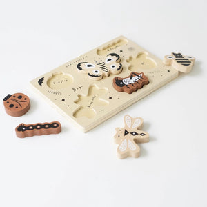 The BUGS TRAY PUZZLE by WEE GALLERY is a wooden puzzle set on a light background, showcasing six insect pieces: a ladybug, a caterpillar, a moth, a bee, a cricket, and a dragonfly. This educational fun bugs set also includes small black stars and the word "Bugs!" emblazoned on the puzzle board.
