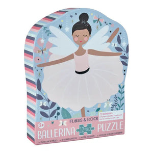 The FLOSS & ROCK Enchanted Ballerina Jigsaw Puzzle features a ballerina in a pink tutu with wings, surrounded by whimsical elements like swans, flowers, and dragonflies. Her shiny foiled costume and the starry tree background create a dreamy fairy-tale atmosphere.
