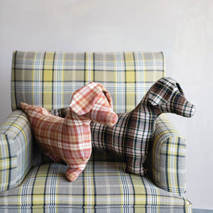 The CREATIVE COOP PLAID DOG-SHAPED PILLOWS, shown here in brown-green and red-orange patterns on a white background, bring cozy farmhouse style to any space.