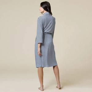 A woman wears a SOFTIES - DREAM SHAWL COLLAR ROBE in pink and white stripes, featuring a shawl collar, a tie waist, and three-quarter length sleeves.