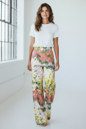The MIRTO 1956 - Brushstroke Print Cotton Trousers by MIRTO 1956 feature a high waist and wide-leg design with a vibrant brushstroke pattern in pink, green, yellow, and white.