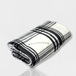 A folded, black-and-white plaid blanket from the FEARRINGTON SIGNATURE COLLECTION by STRAN PROMOTIONAL SOLUTIONS is displayed against a white background. The super-soft throw's sumptuous feel and classic pattern are prominently visible.