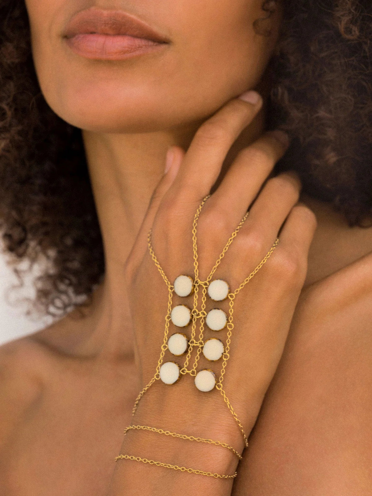 The GOLDISH DOUBLE LADDERS TO BLISS BLACK ONYX CIRCLE STONE NECKLACE, featuring three vertical rows of black onyx stones, is shown on a beige fabric bust stand against a white background.