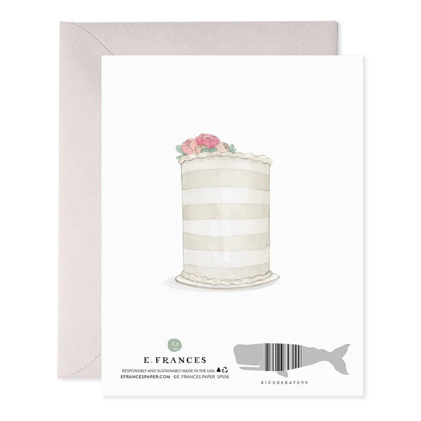 The E. FRANCES PAPER Wedding Rings Greeting Card showcases two intertwined gold rings tied with a gray ribbon and elegant foil accents, inscribed with "FOREVER AND EVER." A handcrafted watercolor touch enhances the card, complemented by a beige envelope.