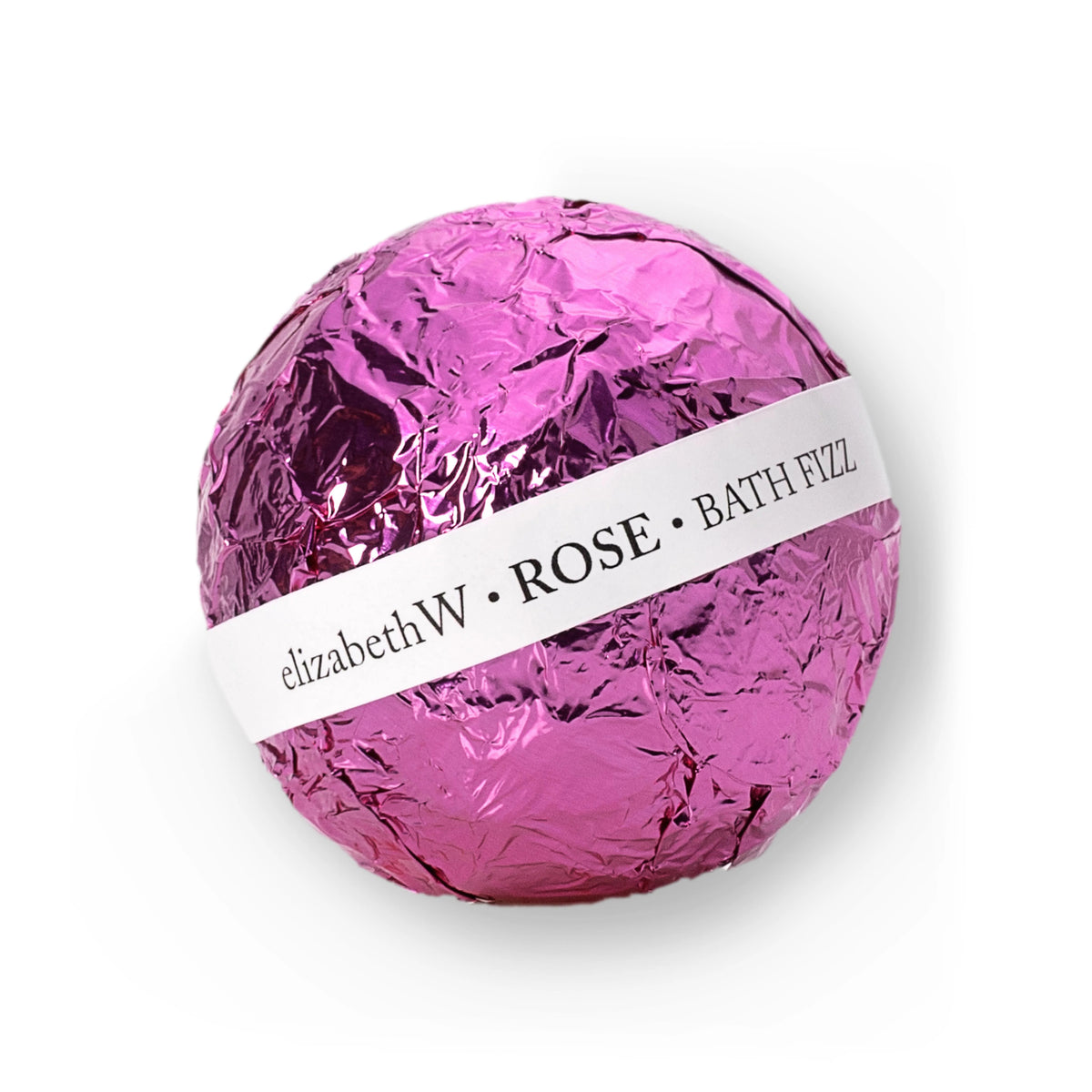 A round, nourishing fizz ball wrapped in shiny pink foil with a white label around its middle. The label reads &quot;E WIGHTMAN &amp; CO BATH FIZZ BALL ROSE.&quot; This E WIGHTMAN &amp; CO bath fizz is designed for bath use, likely offering a delightful rose fragrance.