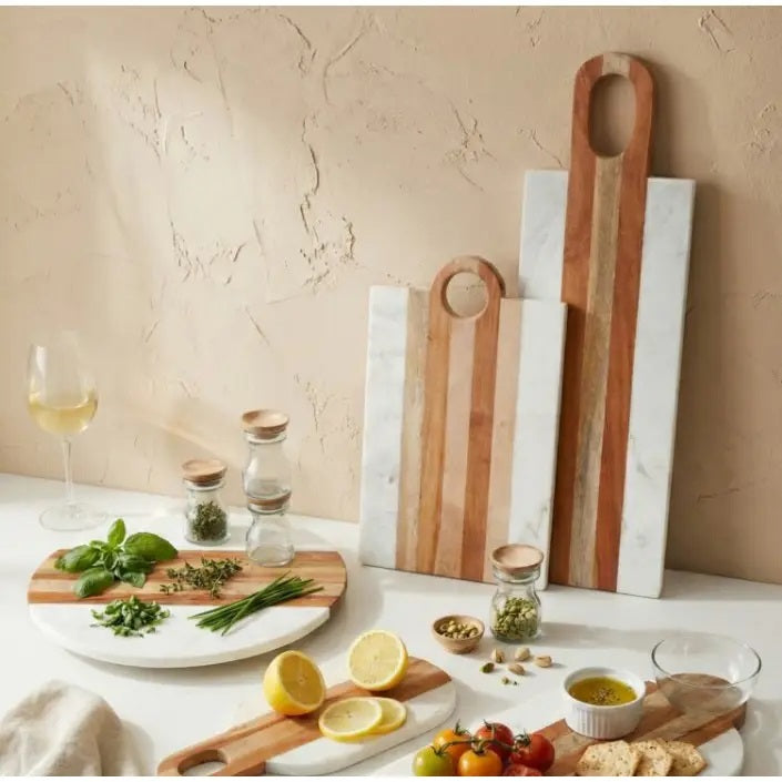 The BE HOME - MOA Marble & Wood Long Board by BE HOME, INC features alternating horizontal marble and wood strips and an oval handle, handcrafted from ethically sourced materials—a stylish choice for your home collection.