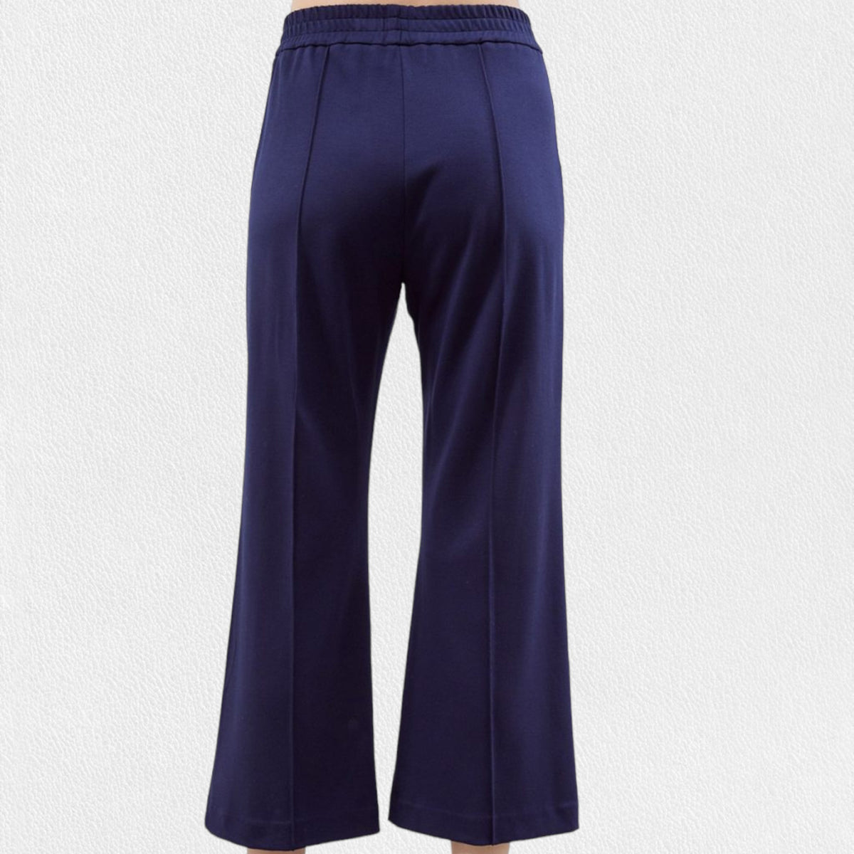 A person is wearing black, pull-on straight-leg cropped pants from MEIMEIJ with an elastic waistband. The bottom part of their legs and feet are visible, highlighting the sleek seam detail, but the top part of the body is not shown. The background is plain white.