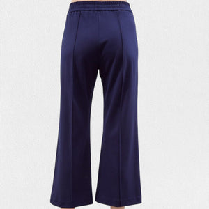 A person is wearing black, pull-on straight-leg cropped pants from MEIMEIJ with an elastic waistband. The bottom part of their legs and feet are visible, highlighting the sleek seam detail, but the top part of the body is not shown. The background is plain white.