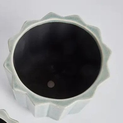 The NAPA HOME AND GARDEN - VELA POT, LARGE by NAPA HOME AND GARDEN features a fully visible ceramic planter with a light blue chevron pattern and textured vertical ridges, forming part of a charming decorative set. A smaller matching pot is partially displayed in the foreground on the left.