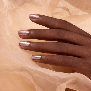 A bottle of MANUCURIST INC GREEN™ Nail Polish in the shade “Cosmic Rose,” showcasing a shimmering rose gold pink hue and topped with a black cap. The label features “green” and “quick dry intense color,” highlighting its vegan and non-toxic formula.