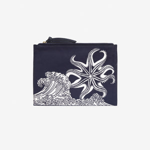 INOUI EDITIONS - POSEIDON POUCH IN NAVY by INOUI features vertical navy and white stripes, a navy zipper, and a small square patch on the front. Inspired by traditional weaving for timeless style, shown against a plain white background.