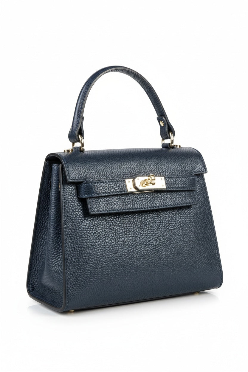 The LE BORSETTE LEATHER SATCHEL BAG is a small, structured satchel-shaped handbag in light pink, featuring a gold clasp at the front. It boasts a single top handle, an adjustable shoulder strap, and two gold-tone hardware pieces on either side of the handle. The textured leather adds to its luxurious and elegant appearance against the plain white background.