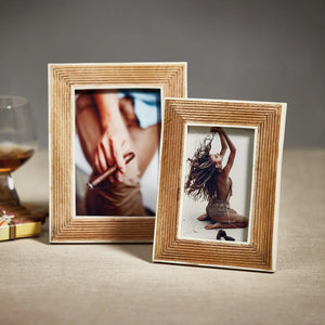 Showcase your cherished memories in the ZODAX Ribbed Mango Wood Frame with White Bone Border – 4x6. This elegant frame features an artisanal ribbed mango wood design accented by a refined white bone border, beautifully displaying a photograph of a person sitting on their knees with back exposed, arms raised, and long hair flowing against a light background.