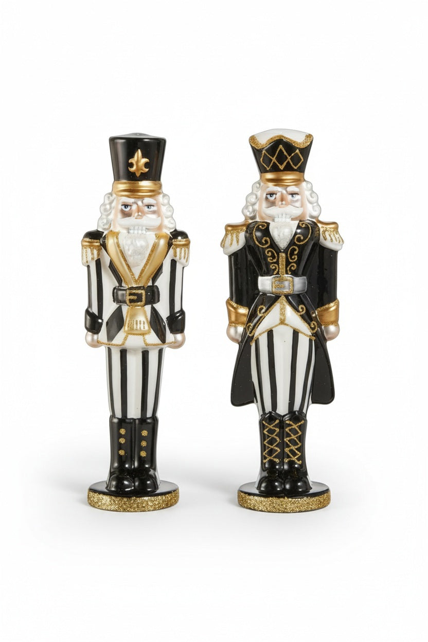 A hand places a BLACK AND WHITE NUTCRACKER with hand-painted embellishments next to an identical one on a marble countertop.
