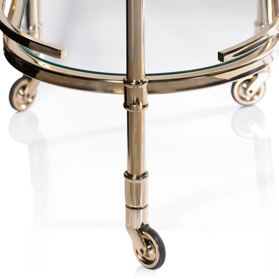 The SPIGA GOLD BAR CART by ZODAX features a vintage Italian-inspired design with elegant gold framing, mirrored glass shelves on both tiers, and smooth-rolling four-wheel mobility. Displayed against a white background, this piece is both stylish and functional.