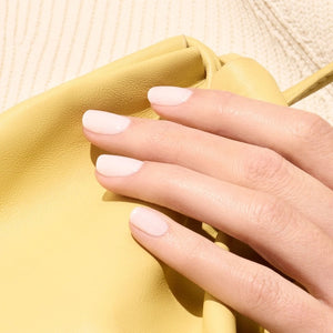 A clear glass bottle of MANUCURIST INC’s GREEN™ Nail Polish in Milky White with a black cap. The label displays “Nail Polish Milky White green Quick Dry Intense Color,” emphasizing its milky white shade and non-toxic, vegan formula.