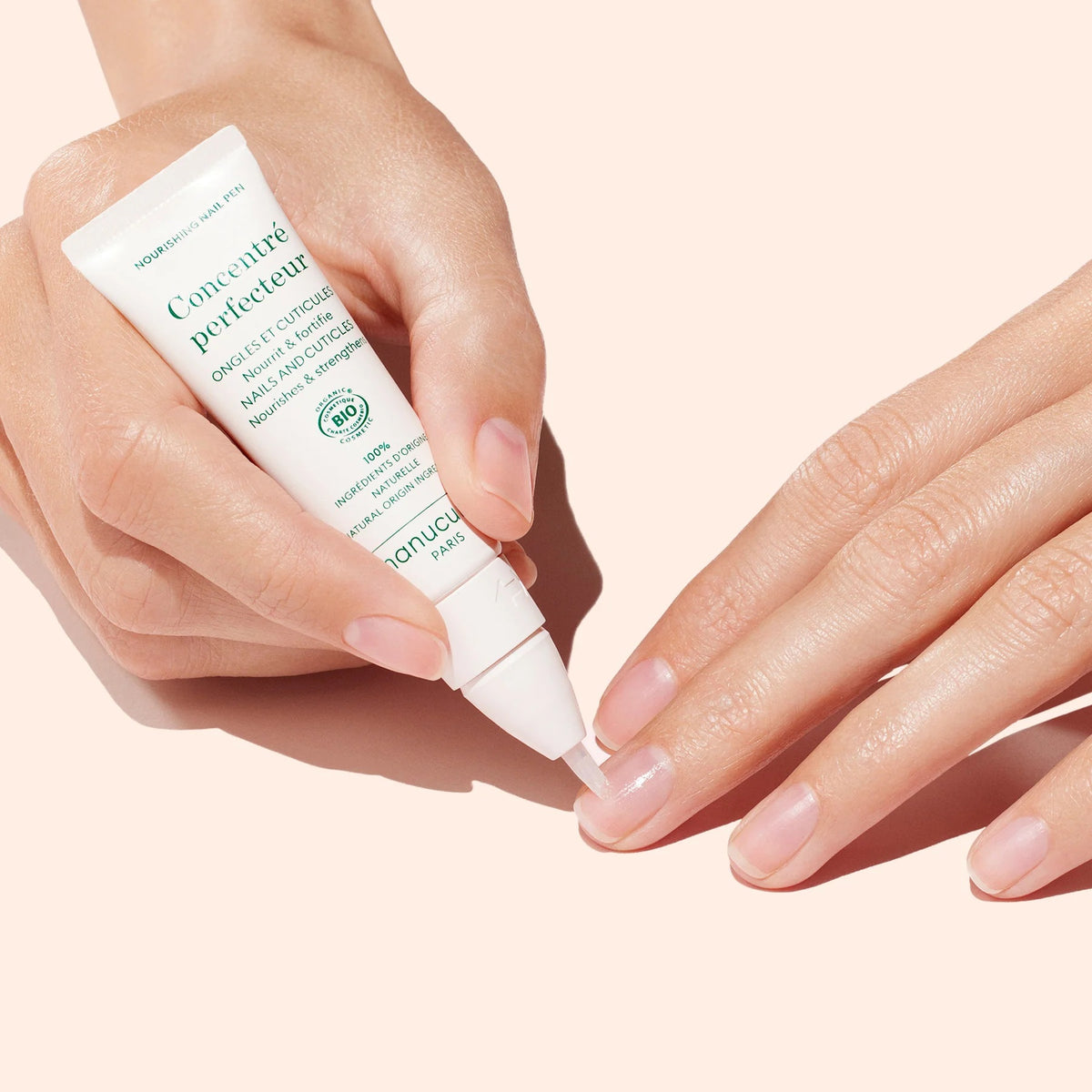 A white tube of MANUCURIST INC MANICURIST - NOURISHING NAIL PEN with green and gray text, featuring a clear applicator tip for effective nail and cuticle care.