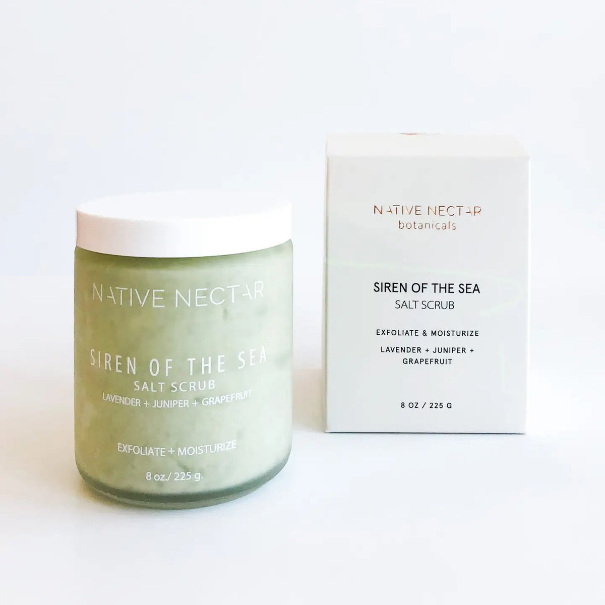 A NATIVE NECTAR - SIREN OF THE SEA SALT SCRUB jar and box are displayed on a white surface. The light green jar with a white lid complements the cream-colored box, showcasing the NATIVE NECTAR brand.