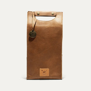 The WILL LEATHER GOODS - DOUBLE LEATHER WINE CASE is a brown full-grain leather tote featuring a top handle cutout, two metal snaps, round metal tag, and stitched "WILL" label—ideal for carrying wine in style.