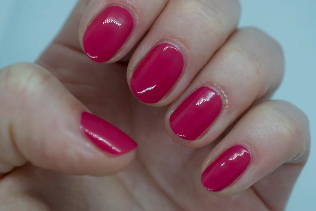 A glass bottle of TENOVERTEN - NAIL POLISH from the brand TEN OVER TEN, featuring a white cap and a dusty pink nail color. The front label displays "TEN OVER TEN" in white uppercase letters. This vegan, eight-free formula ensures both beauty and peace of mind. The background is plain and light-colored.