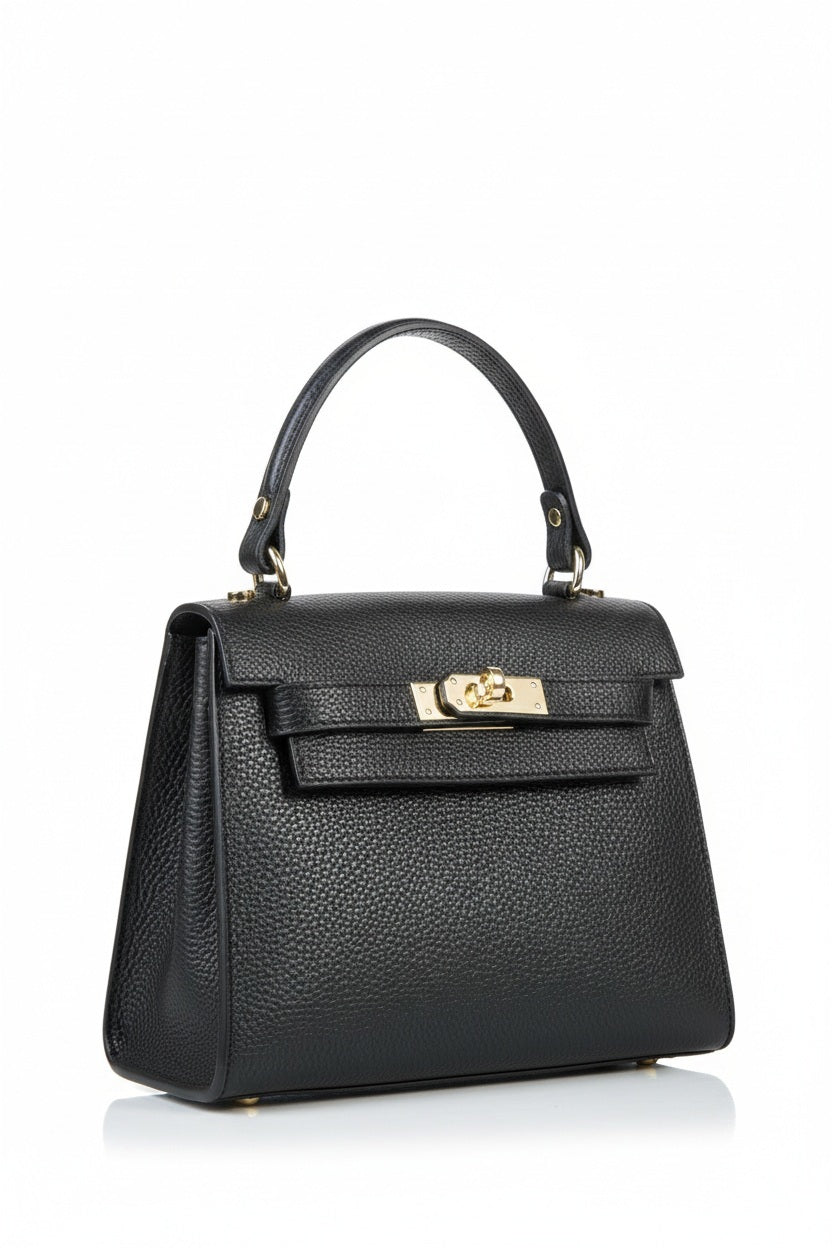The LE BORSETTE LEATHER SATCHEL BAG is a small, structured satchel-shaped handbag in light pink, featuring a gold clasp at the front. It boasts a single top handle, an adjustable shoulder strap, and two gold-tone hardware pieces on either side of the handle. The textured leather adds to its luxurious and elegant appearance against the plain white background.