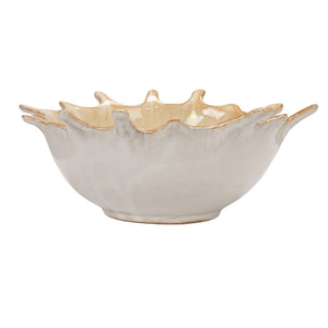 A close-up of the CREATIVE COOP STONEWARE SUNBURST BOWL, a beige ceramic piece with a glossy finish and brown-tinted edges, featuring handcrafted textured details and pointed tips inspired by a leaf’s natural form.