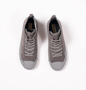 The DANIELLA LEHAVI - OSAKA HIGH TOP SNEAKER by DANIELLA LEHAVI features gray suede uppers and ribbed rubber soles, shown on a white pedestal against a plain light background. These stylish high-tops perfectly combine everyday comfort with modern style.