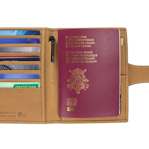 The GARZINI RFID-blocking leather passport holder in camel brown features white stitching and a circular front compartment for an Apple AirTag.