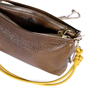 The CRAIE STUDIO DUO BUBBLE UMBER HANDBAG features brown textured vegetable tanned leather with a shoulder strap, silver chain detail, a small front logo, and yellow knot accents on the sides, displayed against a white background.