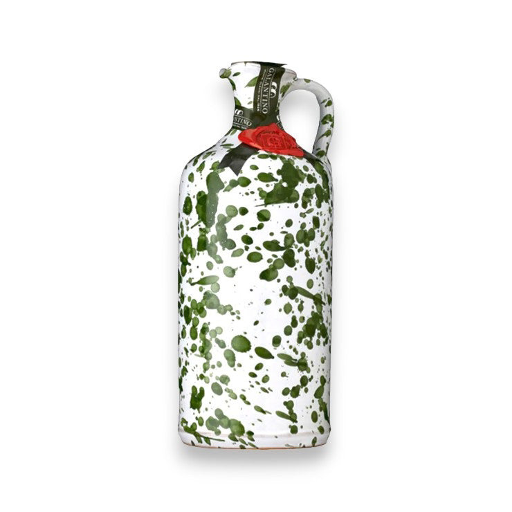 This GALLANTINO - EXTRA VIRGIN OLIVE OIL by ZIA PIA IMPORTS is elegantly contained in a white, hand-painted ceramic bottle with a convenient handle. The bottle is beautifully adorned with green splatter patterns and features a distinguished red wax seal near the top. A green label wrapped gracefully around its neck hints at the premium Ogliarola and Coratina olives used for the luxurious extra virgin olive oil inside. Its artistic design exudes a vintage, handcrafted charm.