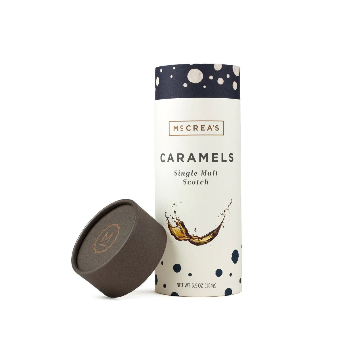 A cylindrical container with a dark lid sits next to it, both adorned with McCrea's Candies branding. The container is labeled "MCCREA'S CANDIES - SINGLE MALT SCOTCH CARAMELS" and features an image of caramel flowing like a liquid. These rich-flavored caramels promise indulgence without the worry of a hangover. The net weight is 5.5 oz (154g).